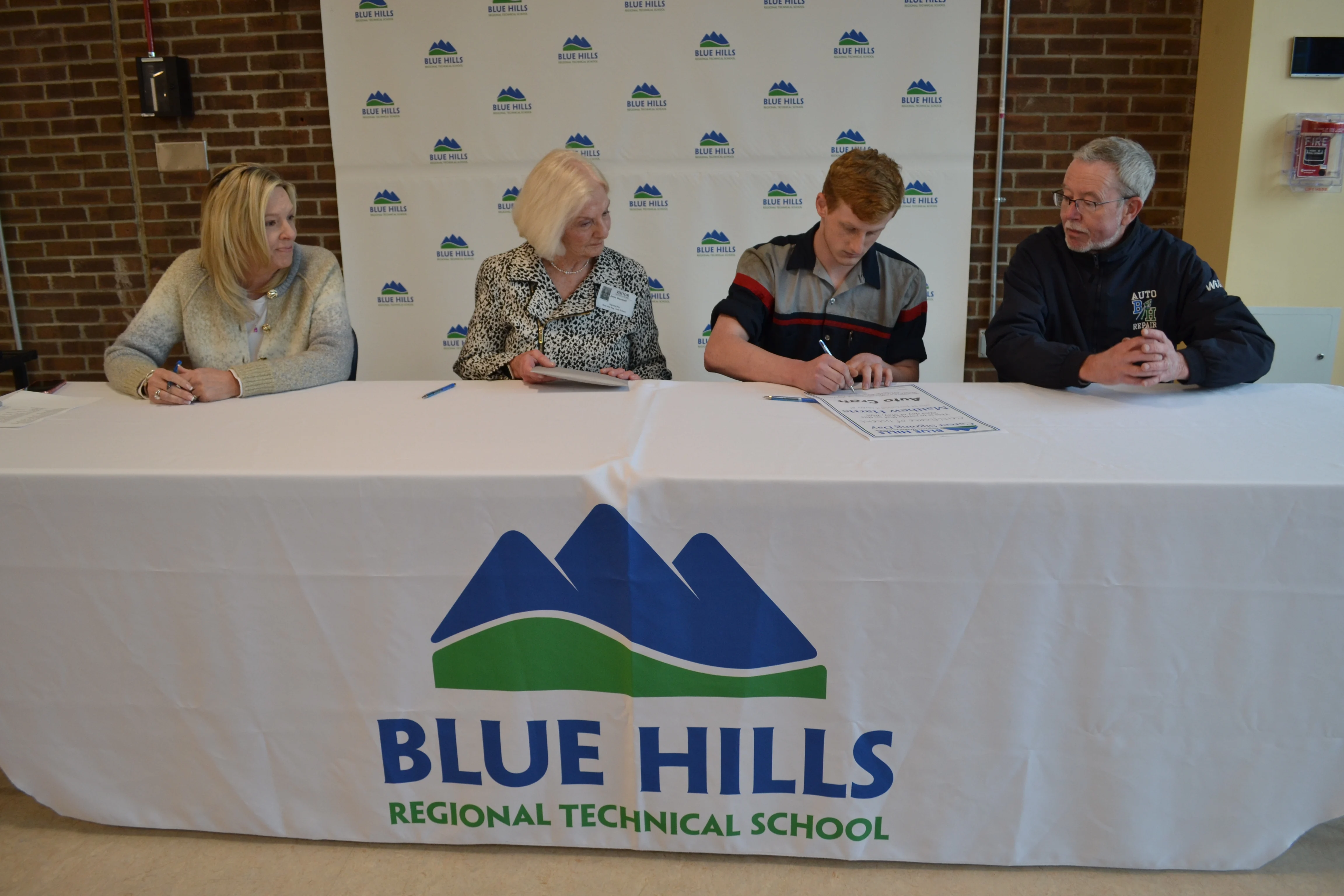 Matthew Harris signing certificate of intent to work with Auto Craft.