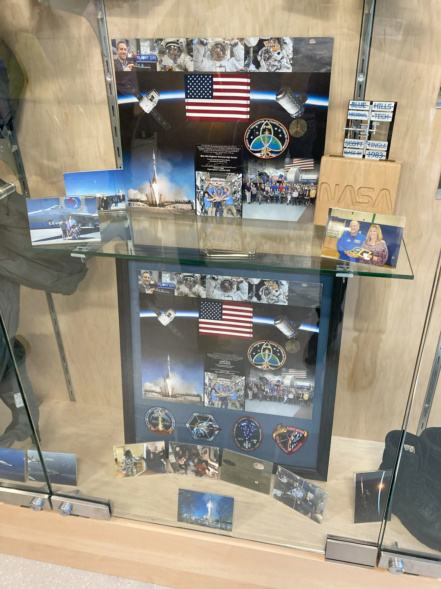The display case features a collection of photographs from Scott Tingle’s time working on the International Space Station.