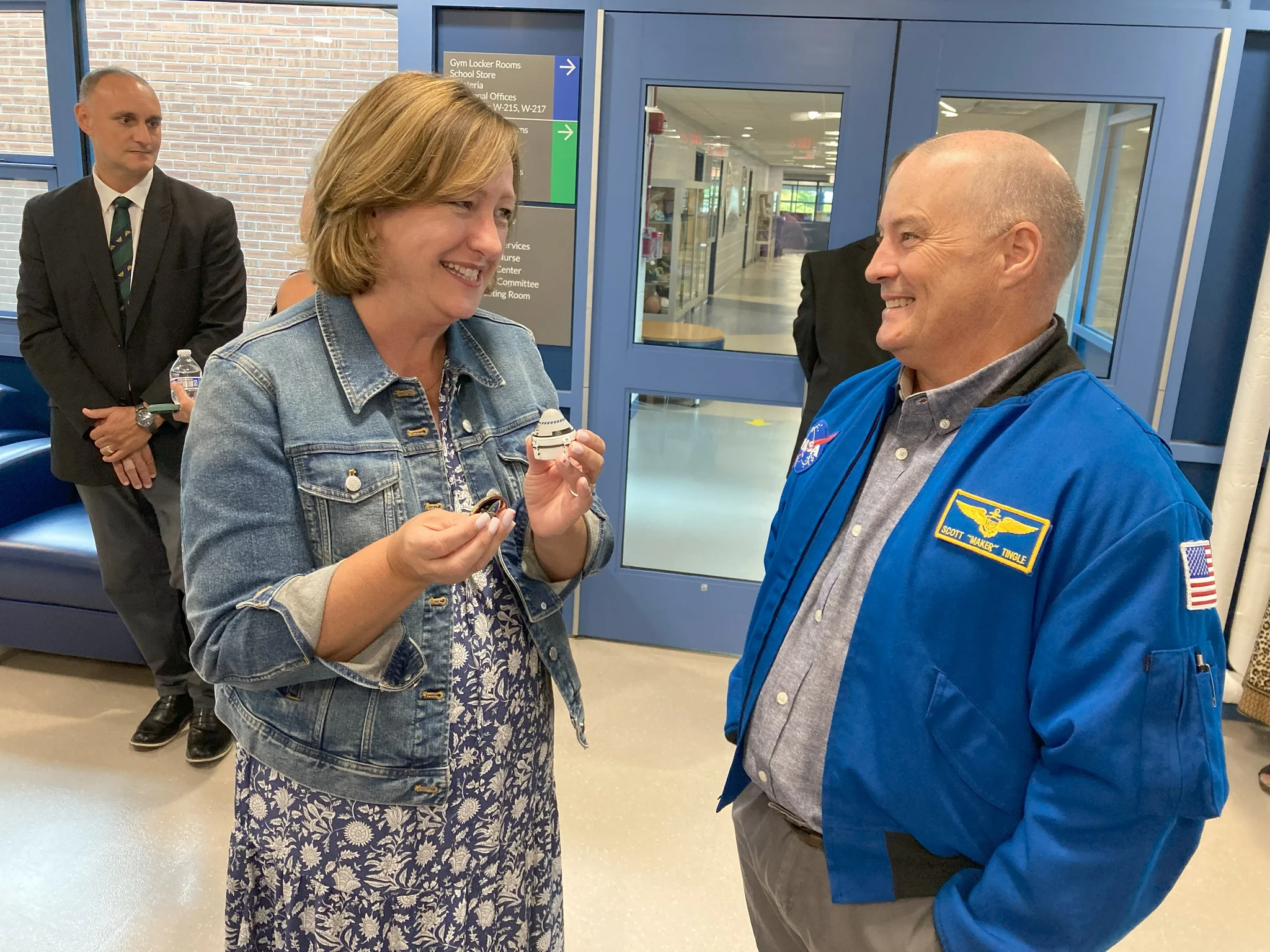 English teacher Eileen Daily received an International Space Station medallion and a tiny model of the Boeing Starliner from NASA astronaut Scott Tingle as gifts for Michael Doucette, a cadet in the U.S. Space Force.
